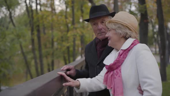 Side View of a Mature Caucasian Couple Standing Next To the Handrails and Talking