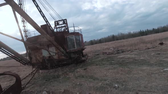 FPV Drone Flies Smoothly Near Rusty Abandoned Walking Excavator