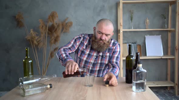 Bearded Millennial Alcoholic Man Drinking Whiskey at Home