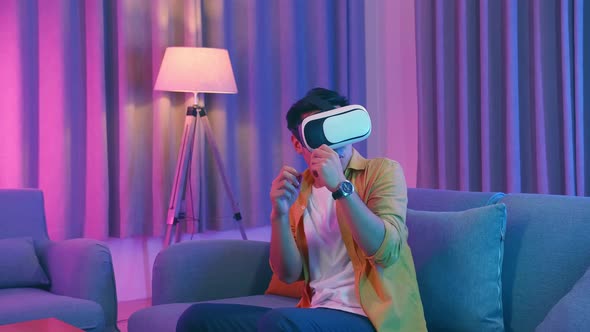 Young Asian Man Scary Virtual Reality In Living Room, Cyan And Magenta Colors