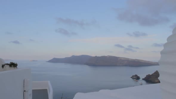 Tracking shot of the majestic caldera view in Oia, Santorini. Thirasia island seen in the background