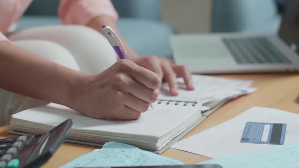 Close Up Of Woman'S Hand Recording The Expenses In Notebook