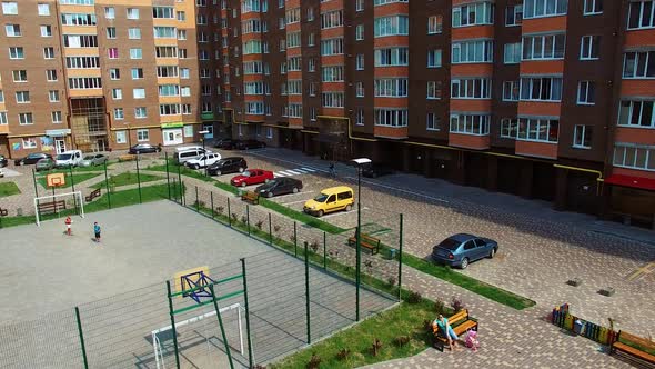 Modern apartment buildings in an urban place. Comfortable children playgrounds and car parking near 