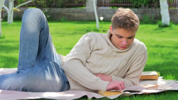 Young Boy Read Book In The Yard