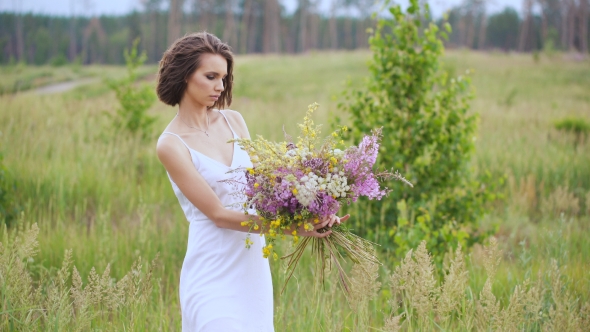 Summer Flowering Field And a Beautiful Girl In a White Sundress.