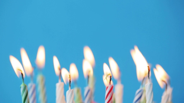 Birthday Candles Burning Over Blue Background