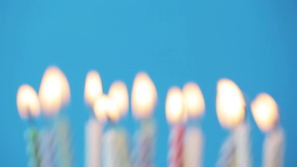 Birthday Candles Burning Over Blue Background