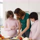 Two Girls with Down Syndrome are Learning to Cook with Their Mother in Kitchen at Home with Fun and - VideoHive Item for Sale