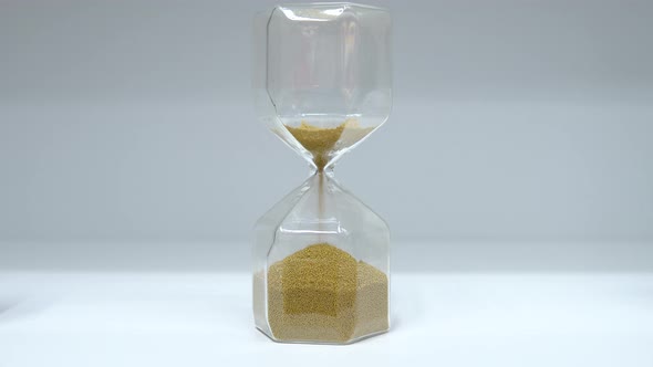 Hourglass Close Up. Glass Hourglass with Small Balls Instead of Sand