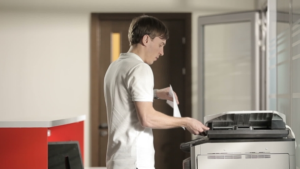 Young Man Printing In The Office