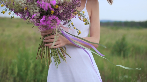 Beautiful Inspired Woman Holds a Bouquet Of Wildflowers.