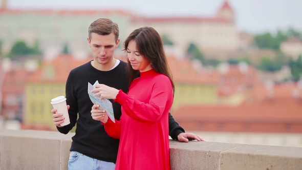 Young Tourist Couple Traveling On Holidays In Europe Smiling Happy. Caucasian Family With City Map