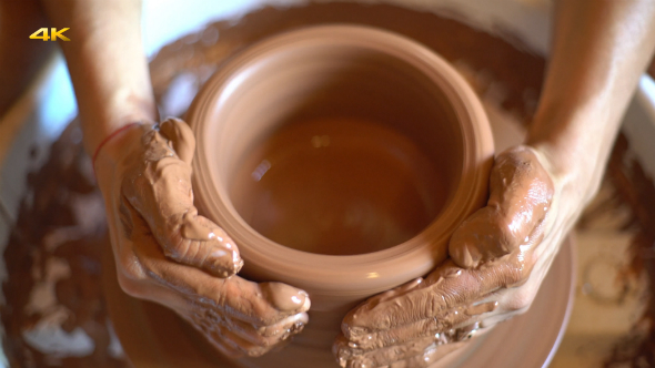 Works With Clay at Potter's Wheel