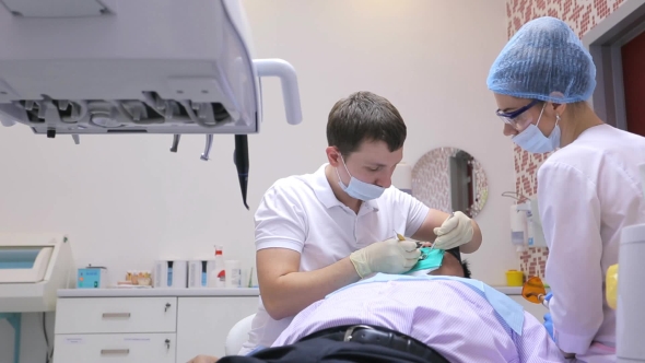 Dentist Is Healing The Teeth Of Male Patient With Dental Scaler And Mirror In Process Of Changing