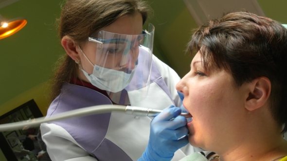 Woman Dentist Working At Her Patients Teeth 