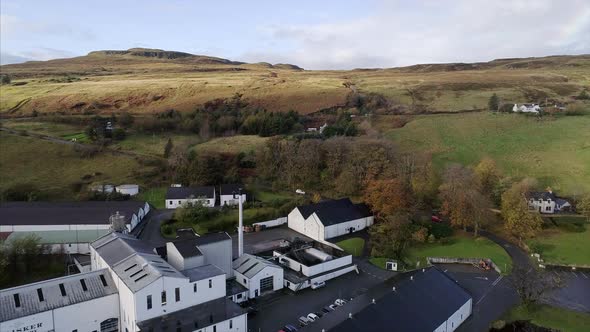 Flying Over a Distillery and Carbost Farm Land in Skye Scotland