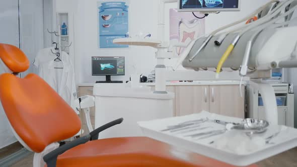 Revealing Shot of Orthodontist Chair with Nobody in Tooth x Ray Images on Display