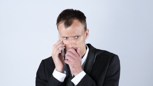 Sad Businessman Worried while Talking on Phone