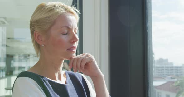 Business woman thoughtful looking through the window