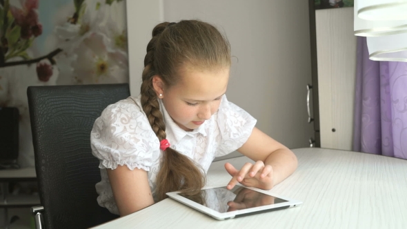 Schoolgirl Uses a Digital Tablet Computer At Home