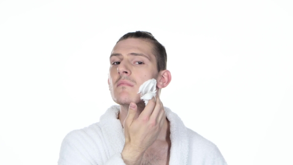 Man Applying Shaving Foam. Hair Tied In Bun. White Background