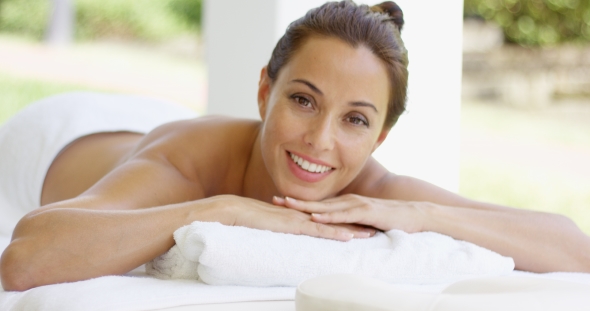Woman With Chin On Folded Towel Smiles