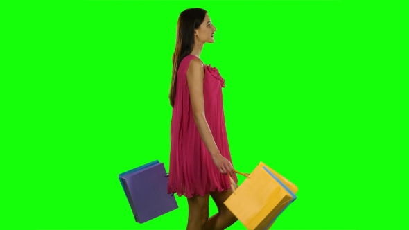 Woman With Shopping Bags Walking. Green Screen