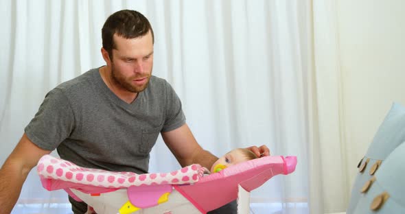 Father looking his baby in bedroom