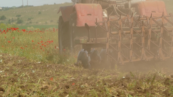 Tractor Cutting Field With Weeds