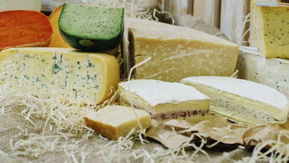 Different Varieties Of Cheese On Display, Lying On Sackcloth And Hay