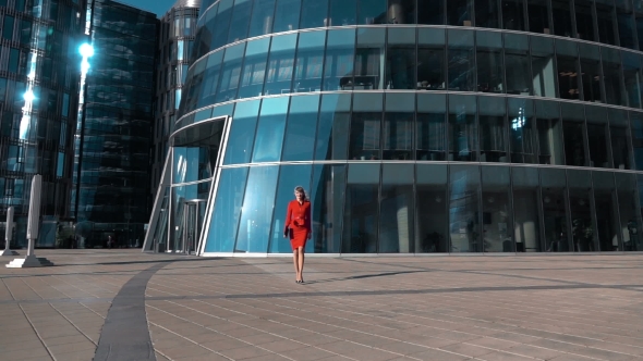 Young Businesswoman Walking Near Glass Building