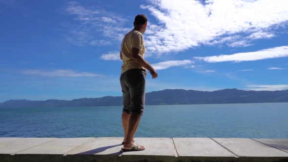 Young Man Plays Ducks And Drakes On Toba Lake