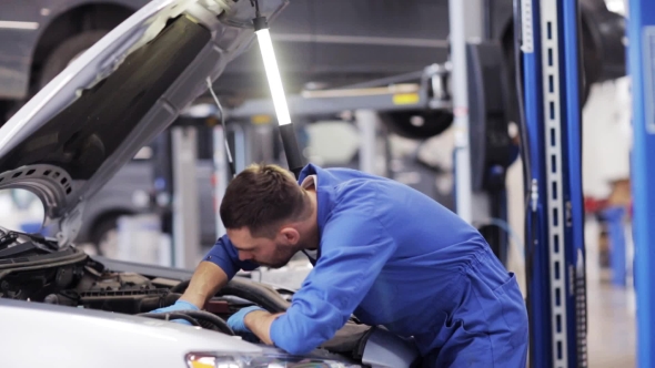 Mechanic Man With Lamp Repairing Car At Workshop 43