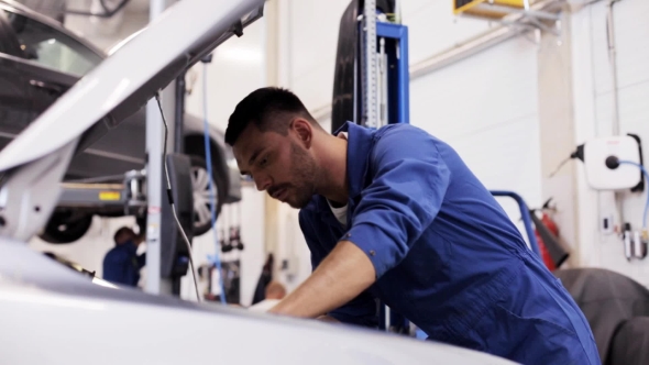 Mechanic Man With Lamp Repairing Car At Workshop 20