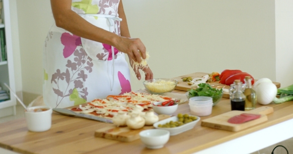 Woman Preparing a Homemade Pizza In The Kitchen