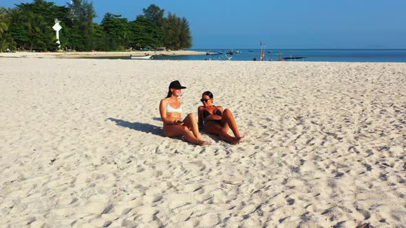Beautiful ladies happy together on luxury resort beach wildlife by clear lagoon and white sandy back