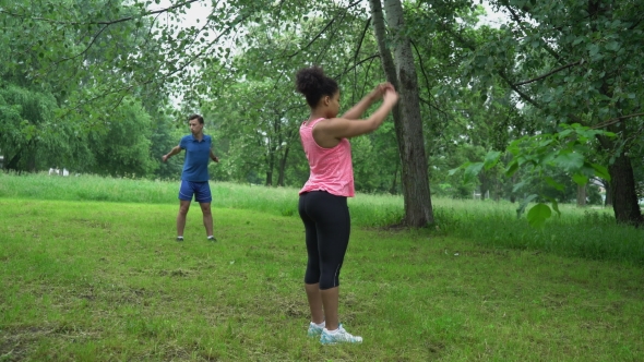 Young Couple Training Together In The Open Air.