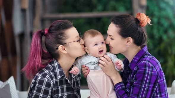 Two Happy Mother Enjoying Kissing and Hugging Little Cute Daughter Medium Shot