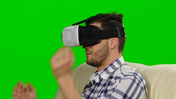 Guy Watches The Plot Of Mask Of Virtual Reality. Green Screen