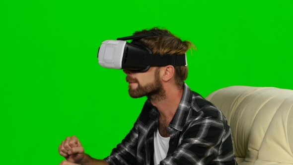 Young Man In a VR Mask Something Catches Hands. Green Screen