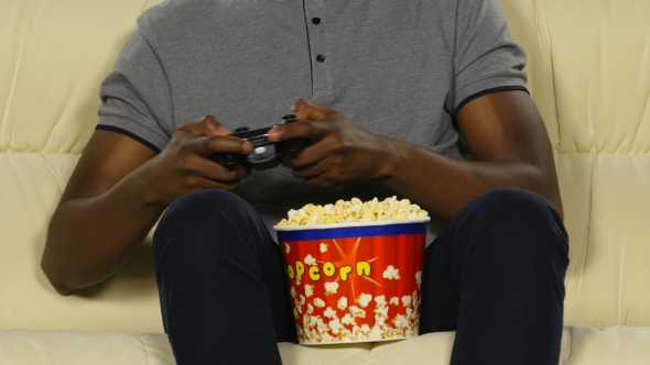 Man Holding a Joystick And Eating Popcorn