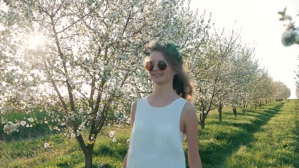 Beauty young woman enjoying nature in spring apple orchard, Happy Beautiful girl in Garden with bloo