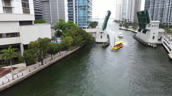 A mobile yacht fueling boat navigates up the Miami River under the Brickell Bridge