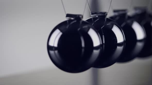 The balls of a Newtons Cradle colliding in slow motion
