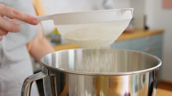 Hand with Strainer Sifting Flour at Home Kitchen