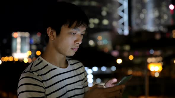 Young man using mobile phone in city