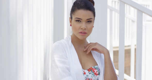 Serious Woman In Bathing Robe Sitting Near Fence