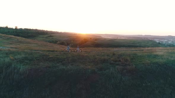 Couple Riding Bicycles in Nature at Sunset