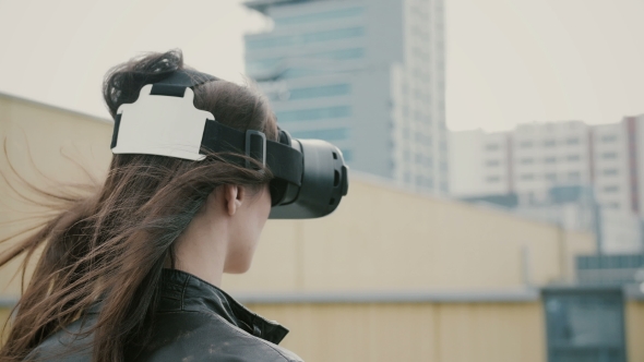 Brunette Girl Uses 3D Virtual Reality Headset on the Roof