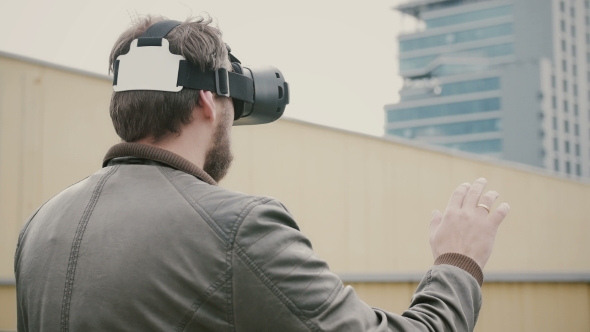 Bearded Attractive Man Uses Virtual Reality Glasses on the Roof